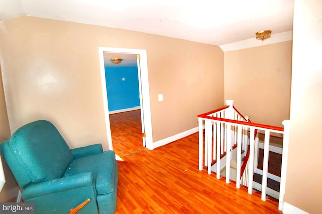 sitting room with vaulted ceiling and hardwood / wood-style floors