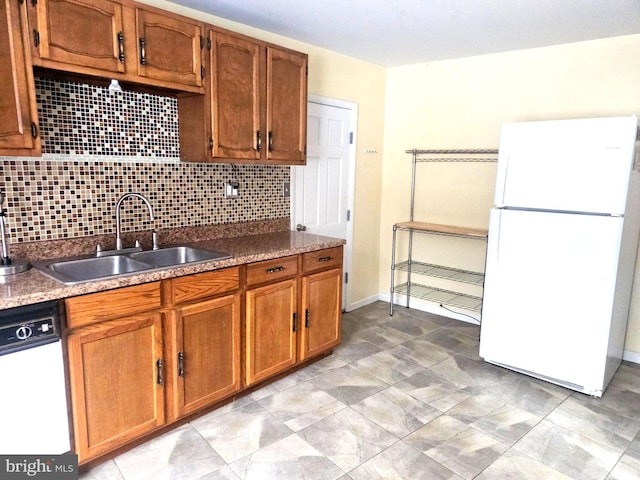 kitchen featuring white fridge, sink, dishwashing machine, and decorative backsplash