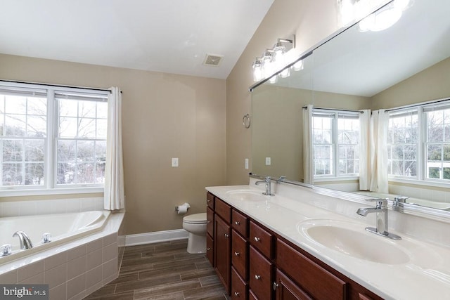 bathroom with tiled bath, a wealth of natural light, and lofted ceiling