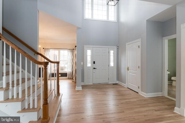 foyer featuring a towering ceiling and light hardwood / wood-style floors