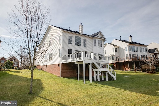 rear view of house featuring a deck and a lawn