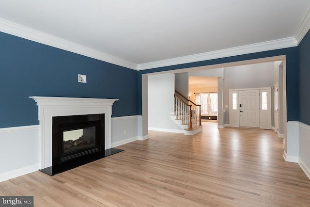 unfurnished living room featuring a multi sided fireplace, light hardwood / wood-style floors, and crown molding