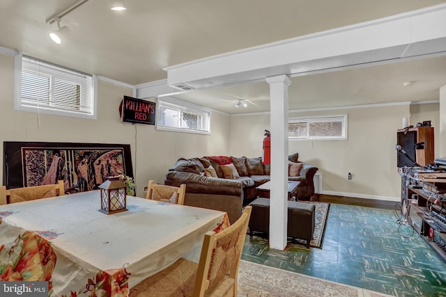 dining space featuring crown molding and track lighting