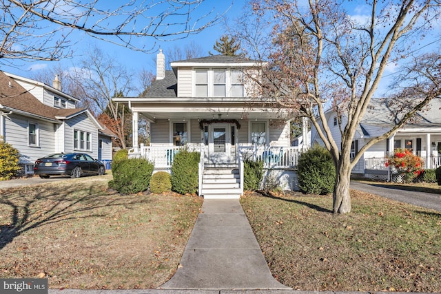 bungalow-style house with covered porch and a front yard