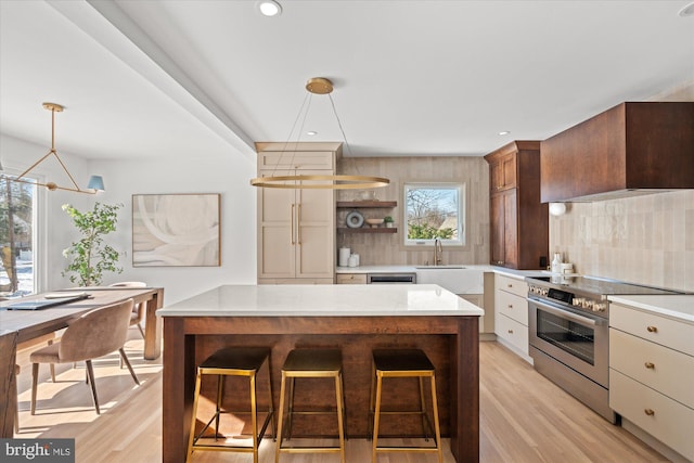 kitchen featuring decorative backsplash, decorative light fixtures, stainless steel appliances, and a healthy amount of sunlight