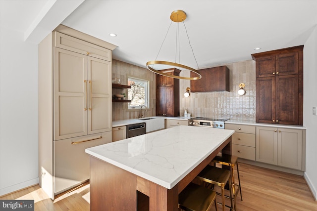 kitchen with cream cabinetry, a kitchen island, dishwasher, and decorative light fixtures