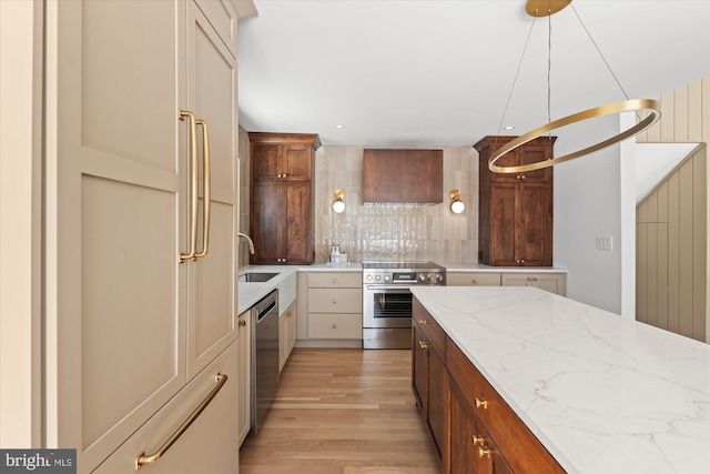 kitchen featuring light hardwood / wood-style floors, appliances with stainless steel finishes, tasteful backsplash, pendant lighting, and light stone counters