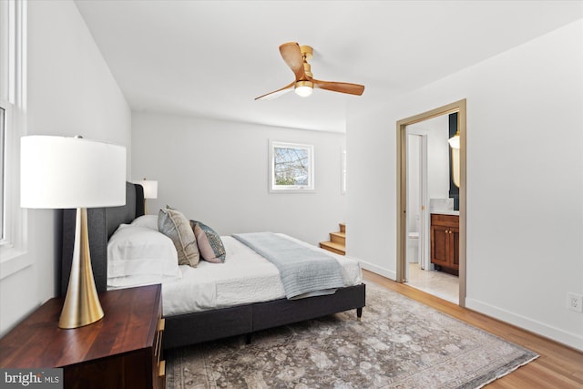 bedroom featuring ceiling fan, connected bathroom, and hardwood / wood-style flooring