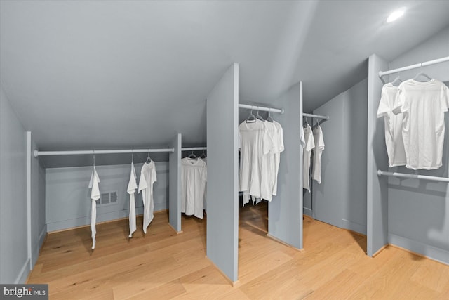 spacious closet featuring vaulted ceiling and hardwood / wood-style floors