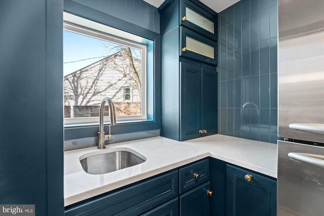 kitchen with sink, stainless steel fridge, and blue cabinetry