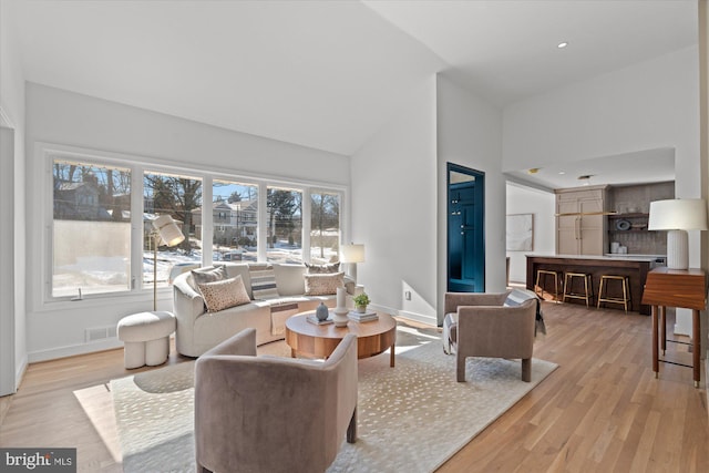 living room featuring light hardwood / wood-style flooring and a high ceiling