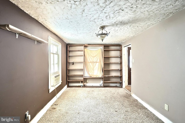 interior space featuring carpet floors, a textured ceiling, and cooling unit