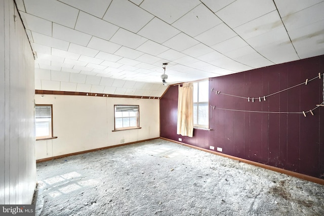 carpeted empty room featuring vaulted ceiling