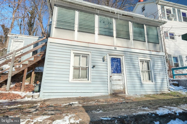 snow covered back of property featuring cooling unit