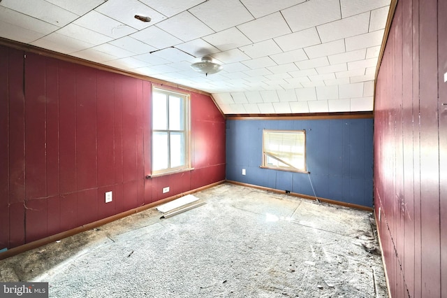 carpeted spare room with lofted ceiling