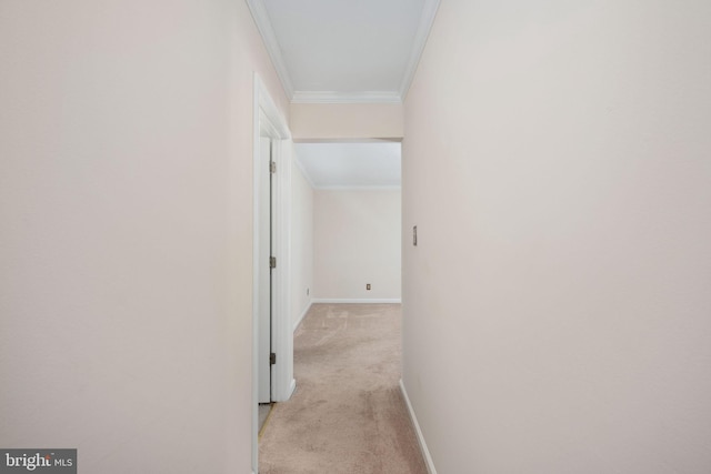 corridor with light carpet, crown molding, and baseboards