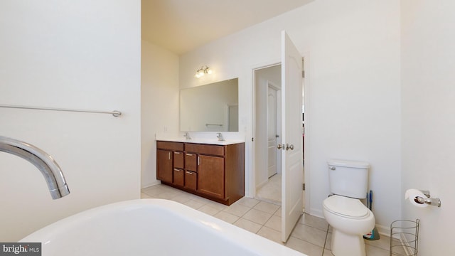 bathroom featuring tile patterned flooring, vanity, a bathtub, and toilet