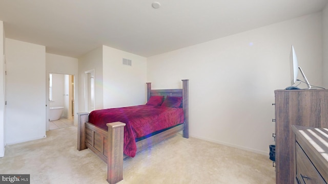 bedroom with light colored carpet and ensuite bathroom