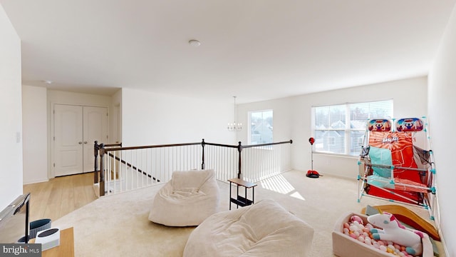 game room featuring light colored carpet and a chandelier