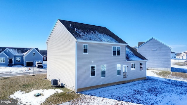 snow covered property featuring central AC