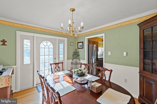 dining room featuring crown molding, a chandelier, and light wood-type flooring