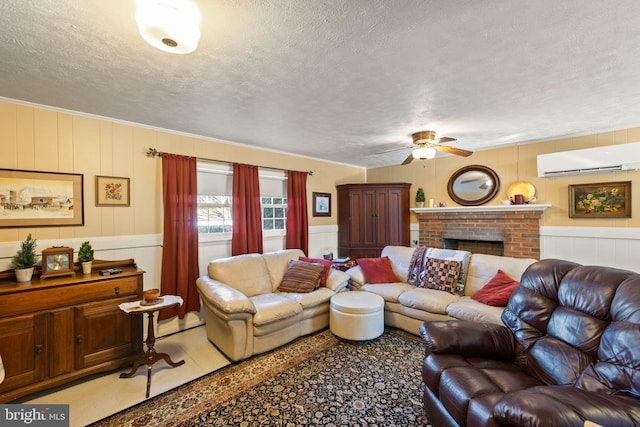 living room featuring ceiling fan, a wall mounted air conditioner, a fireplace, and a textured ceiling