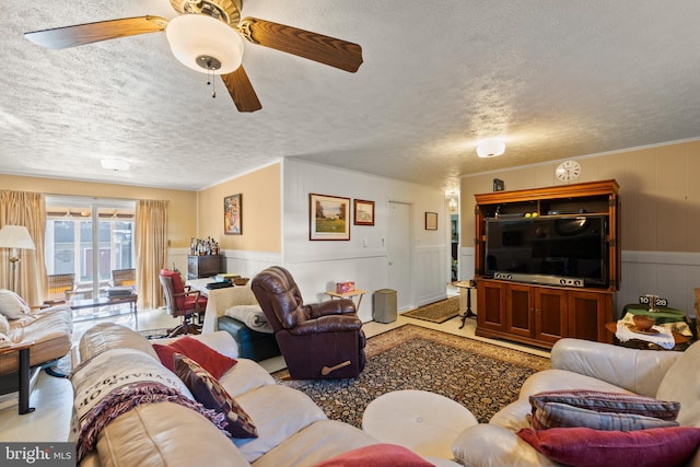 living room with ceiling fan and a textured ceiling