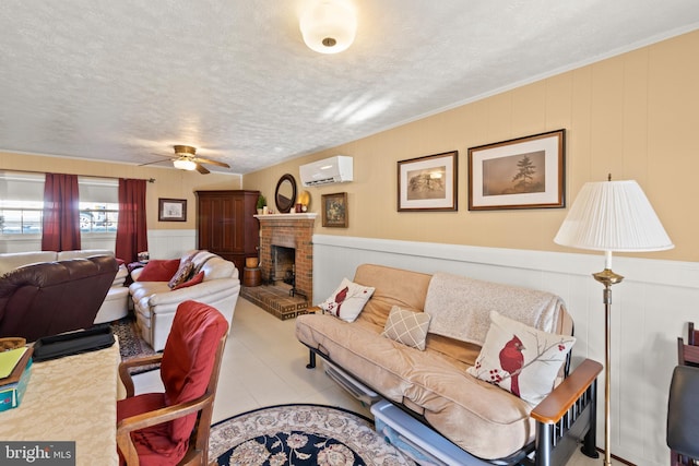 living room featuring a brick fireplace, a wall unit AC, a textured ceiling, and ceiling fan