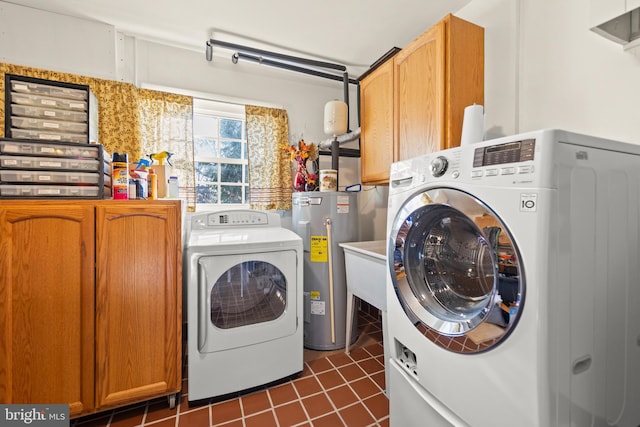 laundry area with separate washer and dryer, electric water heater, cabinets, and dark tile patterned floors