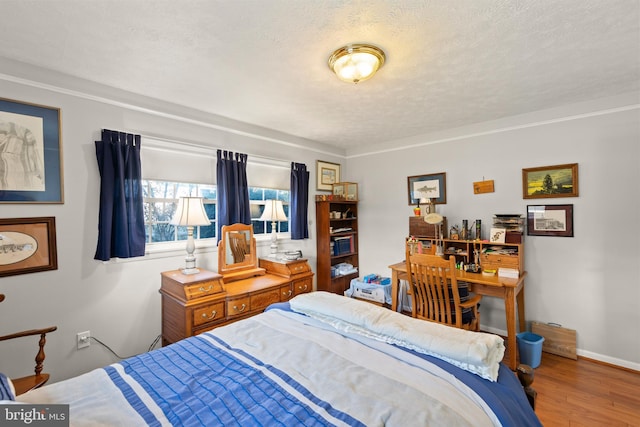 bedroom featuring wood-type flooring and a textured ceiling