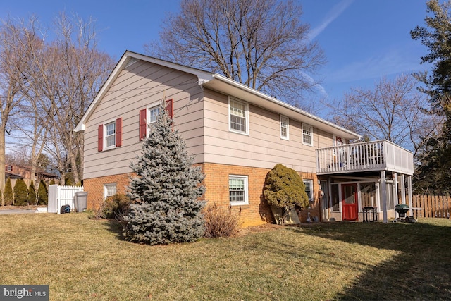 rear view of property featuring a deck and a lawn