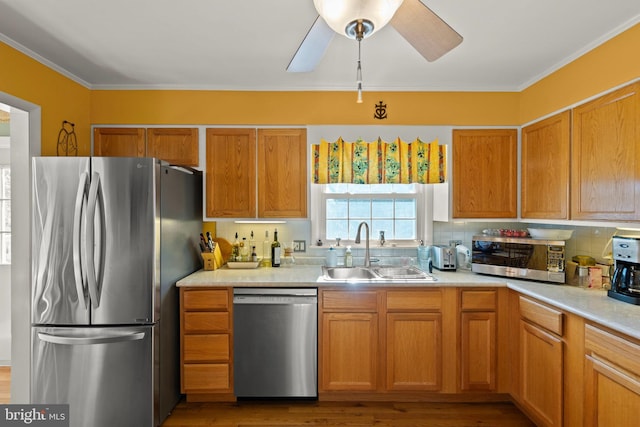 kitchen featuring tasteful backsplash, appliances with stainless steel finishes, sink, and light hardwood / wood-style flooring