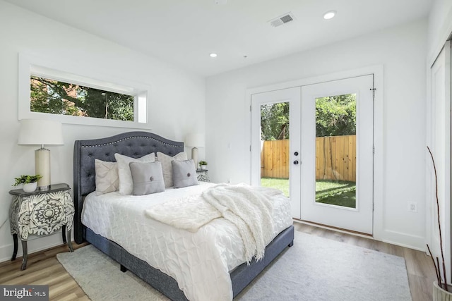 bedroom featuring french doors, hardwood / wood-style floors, and access to outside