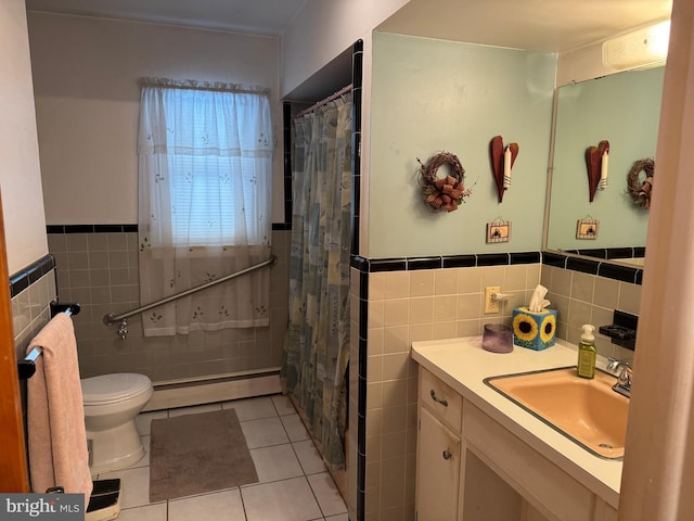 bathroom featuring baseboard heating, vanity, tile patterned floors, and tile walls