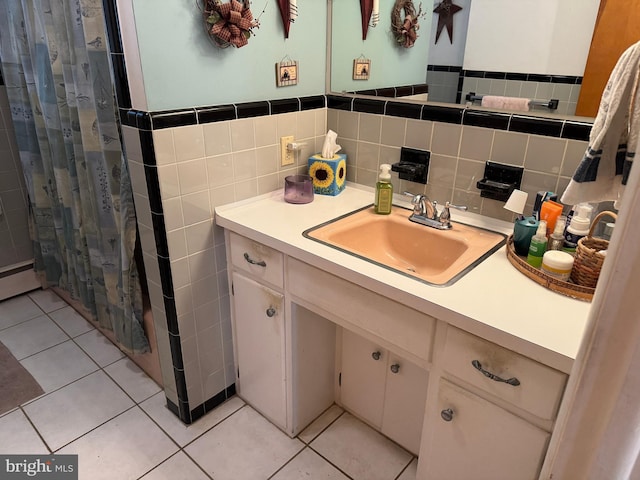 bathroom featuring baseboard heating, vanity, tile patterned floors, and tile walls