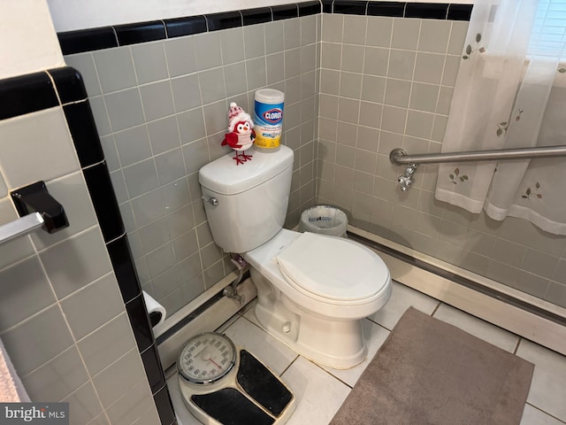 bathroom featuring toilet, tile walls, and tile patterned flooring