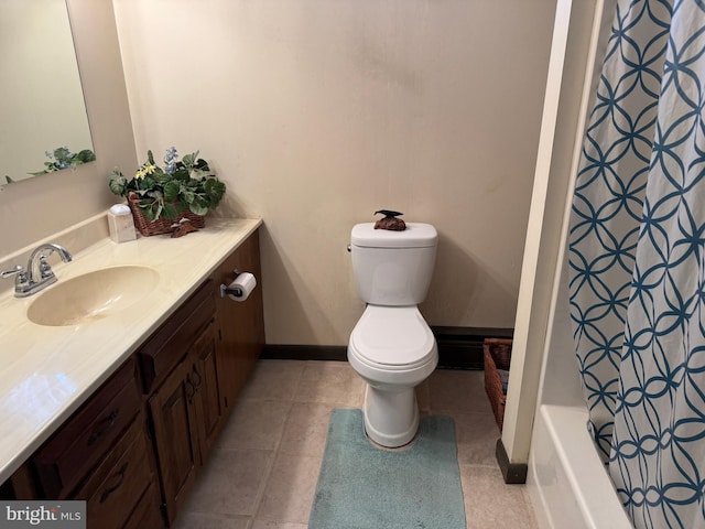 bathroom with toilet, vanity, and tile patterned flooring