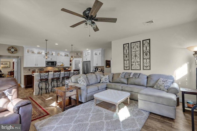 living room featuring ceiling fan and light wood-type flooring