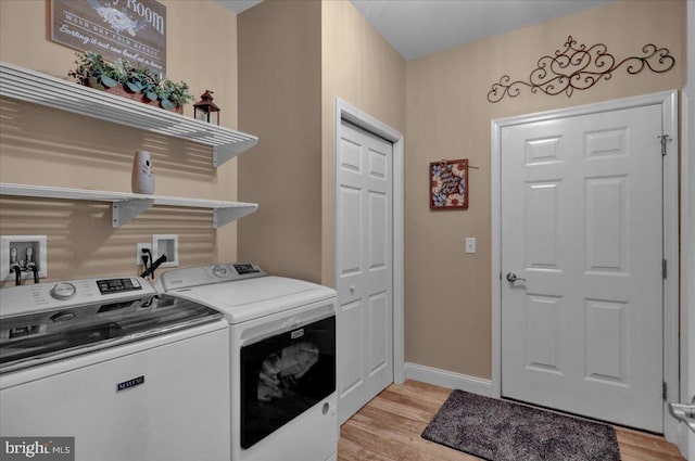 laundry area featuring washer and clothes dryer and light wood-type flooring