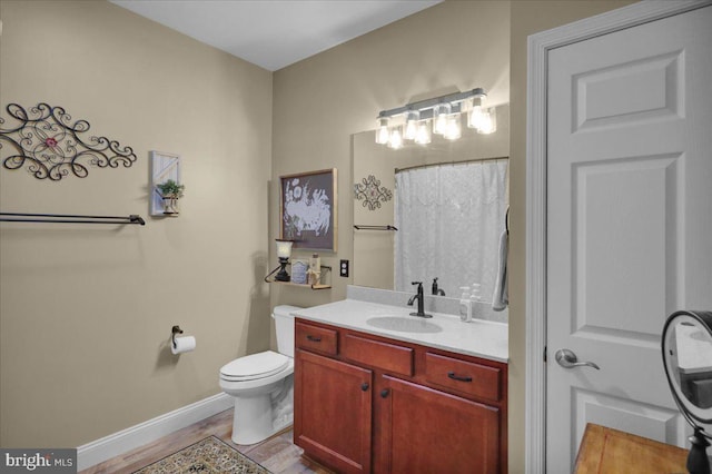 bathroom with hardwood / wood-style flooring, vanity, curtained shower, and toilet