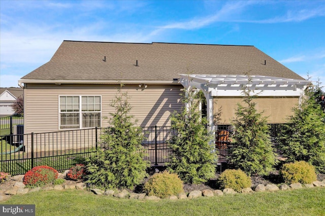 back of house with a yard and a pergola