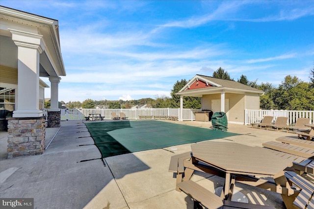 view of pool with a shed and a patio area