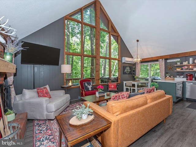 living room with an AC wall unit, dark hardwood / wood-style floors, high vaulted ceiling, a chandelier, and a brick fireplace