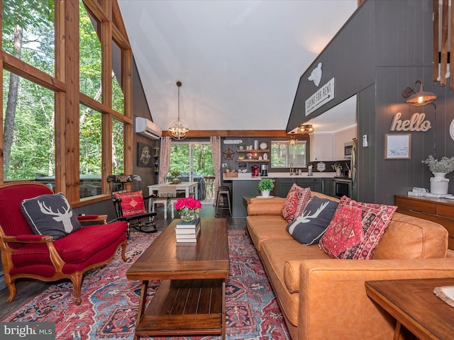 living room with high vaulted ceiling, sink, a chandelier, and a wall unit AC