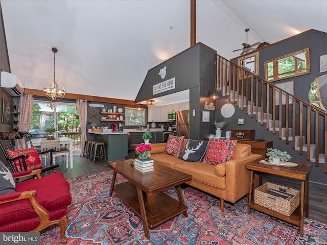 living room with ceiling fan with notable chandelier, wood-type flooring, sink, and high vaulted ceiling