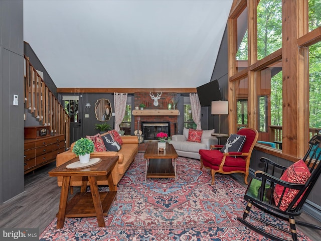 living room with hardwood / wood-style floors, a fireplace, and high vaulted ceiling