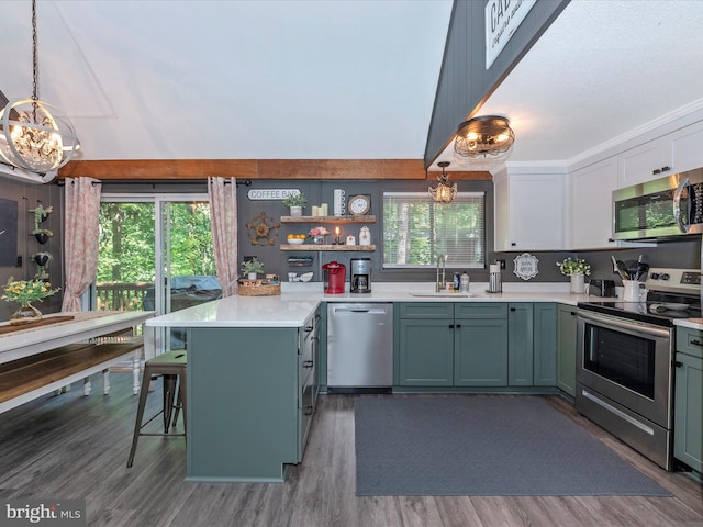 kitchen with sink, decorative light fixtures, stainless steel appliances, and a breakfast bar