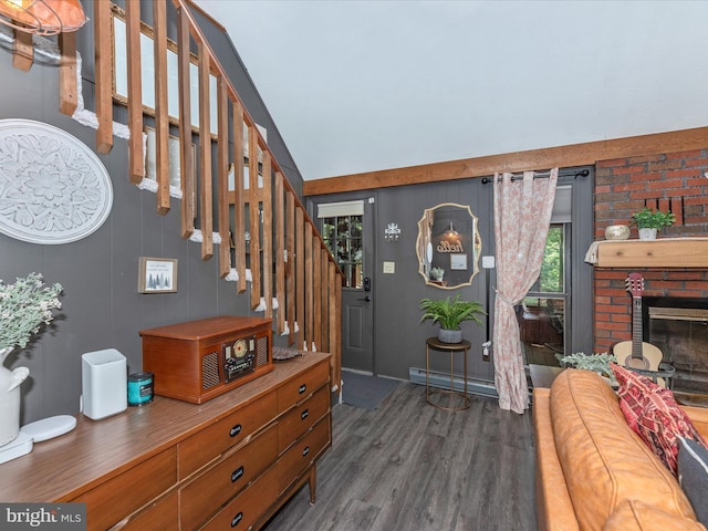 foyer featuring a brick fireplace, a baseboard heating unit, lofted ceiling, and dark hardwood / wood-style flooring