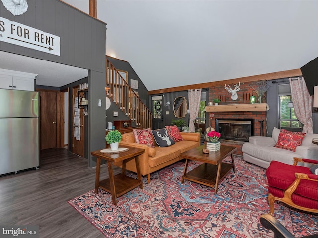 living room with a fireplace, wood-type flooring, and high vaulted ceiling