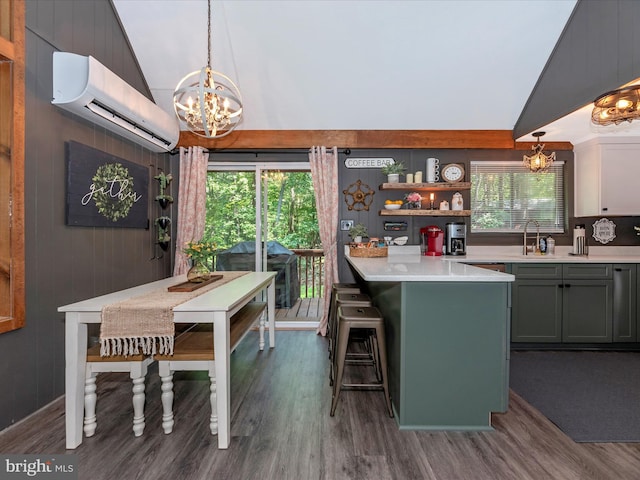 kitchen featuring lofted ceiling, a wall unit AC, pendant lighting, and a kitchen bar